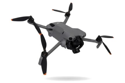 DJI Mini 5 Pro schräg von der Seite mit ausgeklappten Armen, Propellern und Kamera-Gimbal